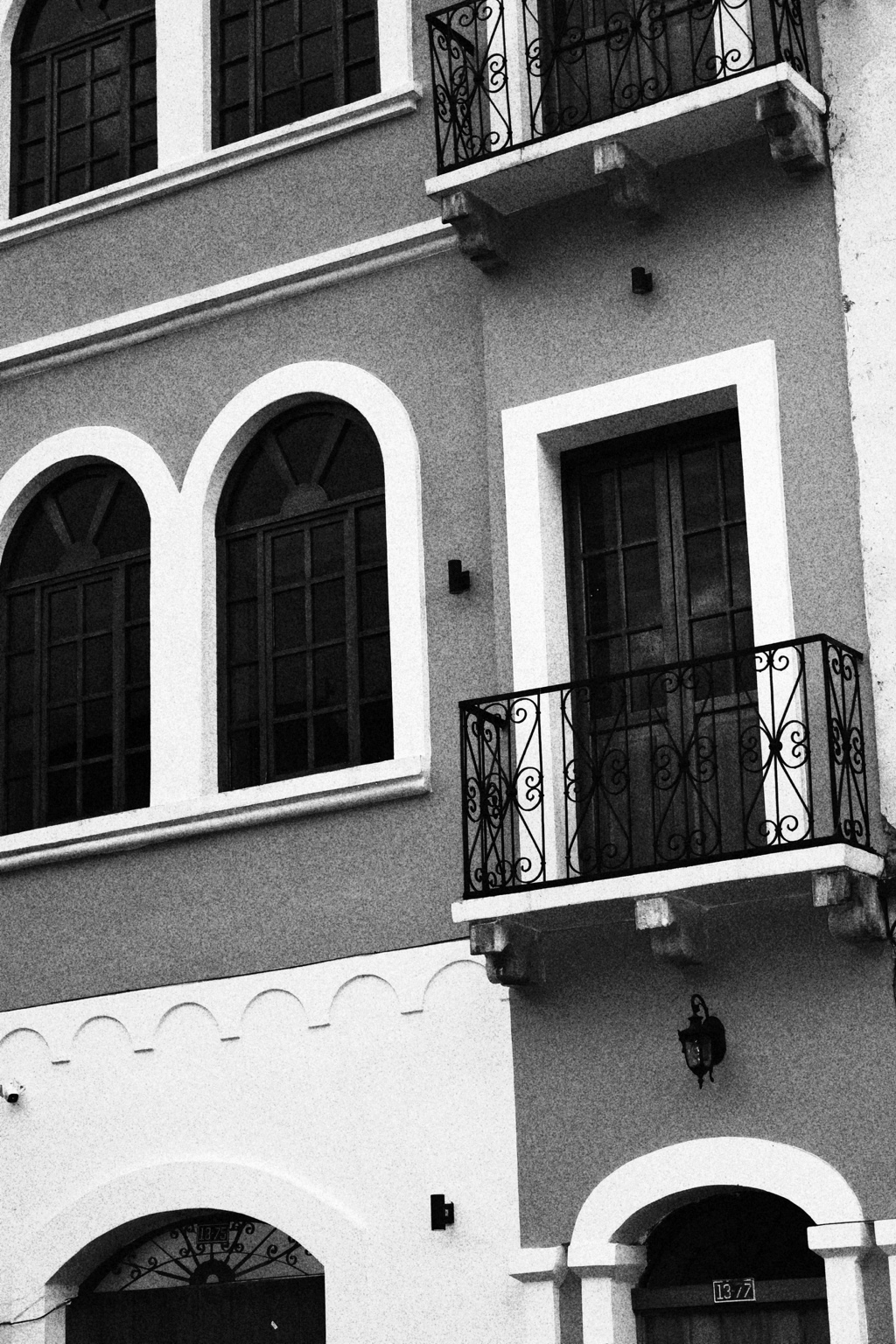 Fachada histórica de Casa Sucre en blanco y negro, con balcones de hierro y grandes ventanas